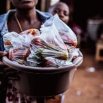 Woman-selling-fresh-vegetables-in-plastic-bags-at-outdoor-market-showcasing-local-trade.-2025-04-30T153840.305-0400-pexels-photo-31853435
