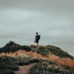 A-man-stands-atop-a-hill-in-Chance-Cove-NL-capturing-natures-beauty.-2025-05-19T121513.407-0400-pexels-photo-9959293