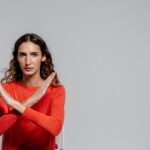 Woman-with-crossed-arms-making-an-X-gesture-against-a-gray-background-indoor-portrait.-2025-05-21T060416.949-0400-pexels-photo-8638231
