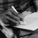 A-close-up-black-and-white-image-of-a-person-writing-in-a-notebook-capturing-the-essence-of-expression.-2025-09-20T060438.181-0400-pexels-photo-5702412