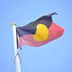 Australian-Aboriginal-flag-waving-against-a-clear-blue-sky-symbolizing-culture-and-heritage.-2025-09-29T153758.185-0400-pexels-photo-28840846