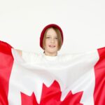 Cheerful-child-celebrates-Canada-Day-with-a-Canadian-flag-indoors-showcasing-patriotism.-2025-10-17T153807.747-0400-pexels-photo-7144816