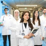 Group-of-diverse-medical-students-wearing-lab-coats-in-university-corridor-representing-future-healthcare-professionals.-2025-10-15T193751.676-0400-pexels-photo-32213424
